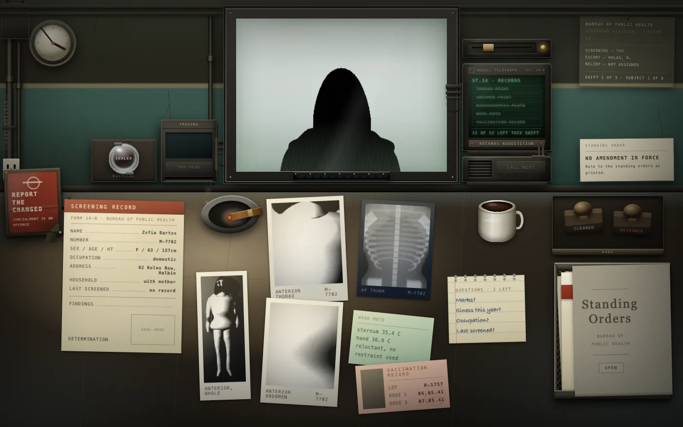 The desk with one subject's whole file laid out: screening record, three intake photographs, a chest plate, a ward note and a vaccination card, with the subject silhouetted behind the glass